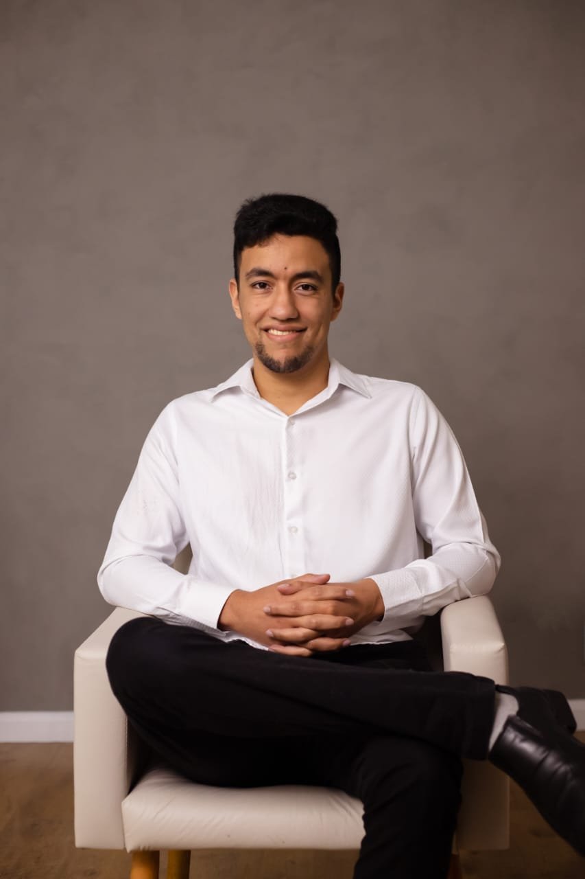 Retrato profissional de João Zvir sentado, usando camisa branca